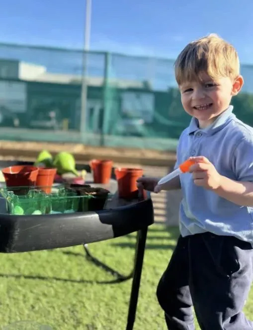 bloom childcare child planting seedlings outdoors