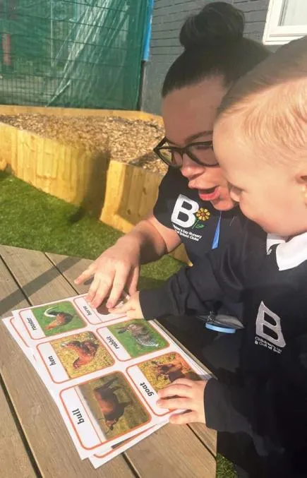 bloom childcare practitioner and child learning outdoors together